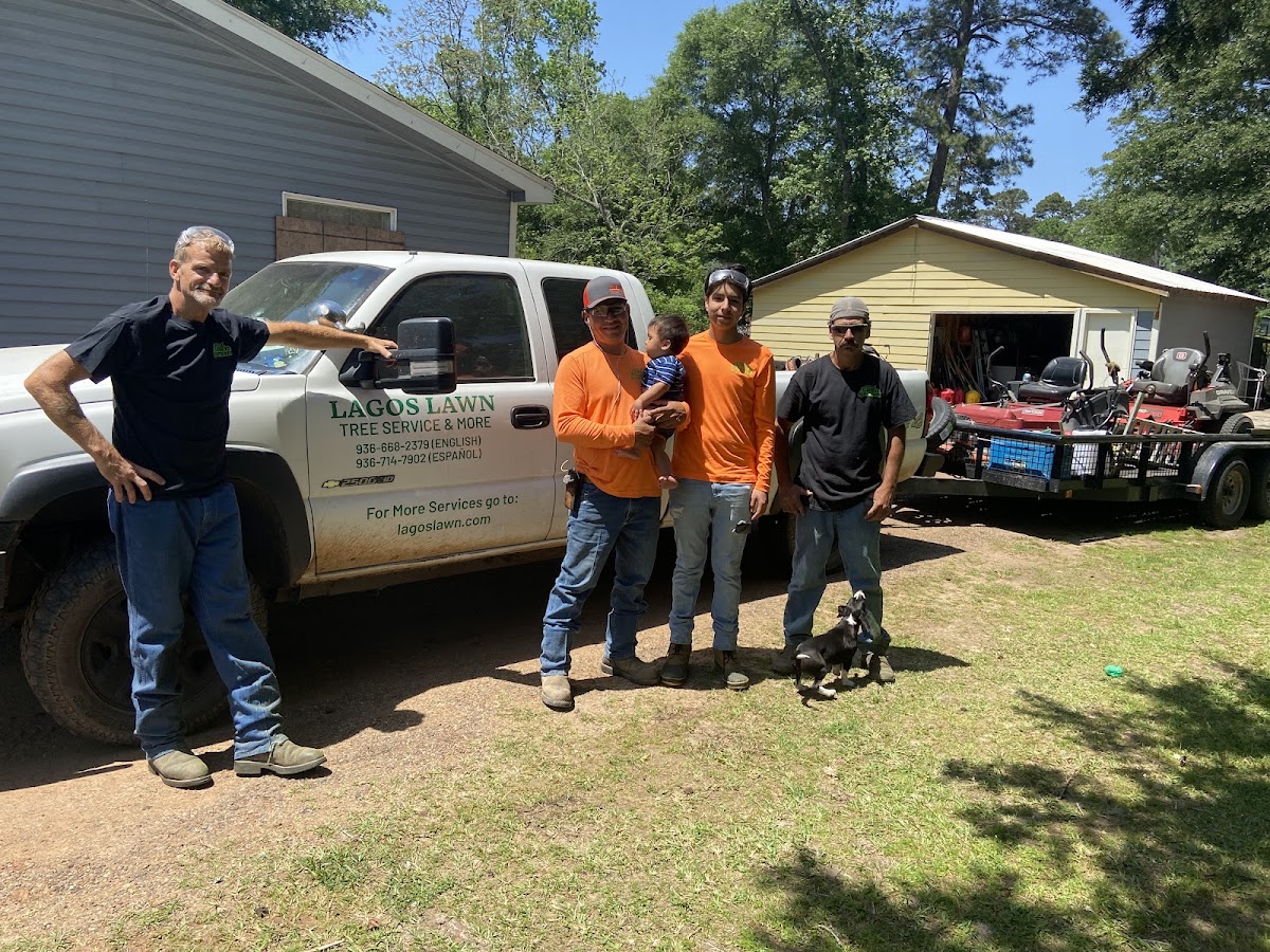 The Lagos Lawn Care crew with their branded truck in Huntsville, TX