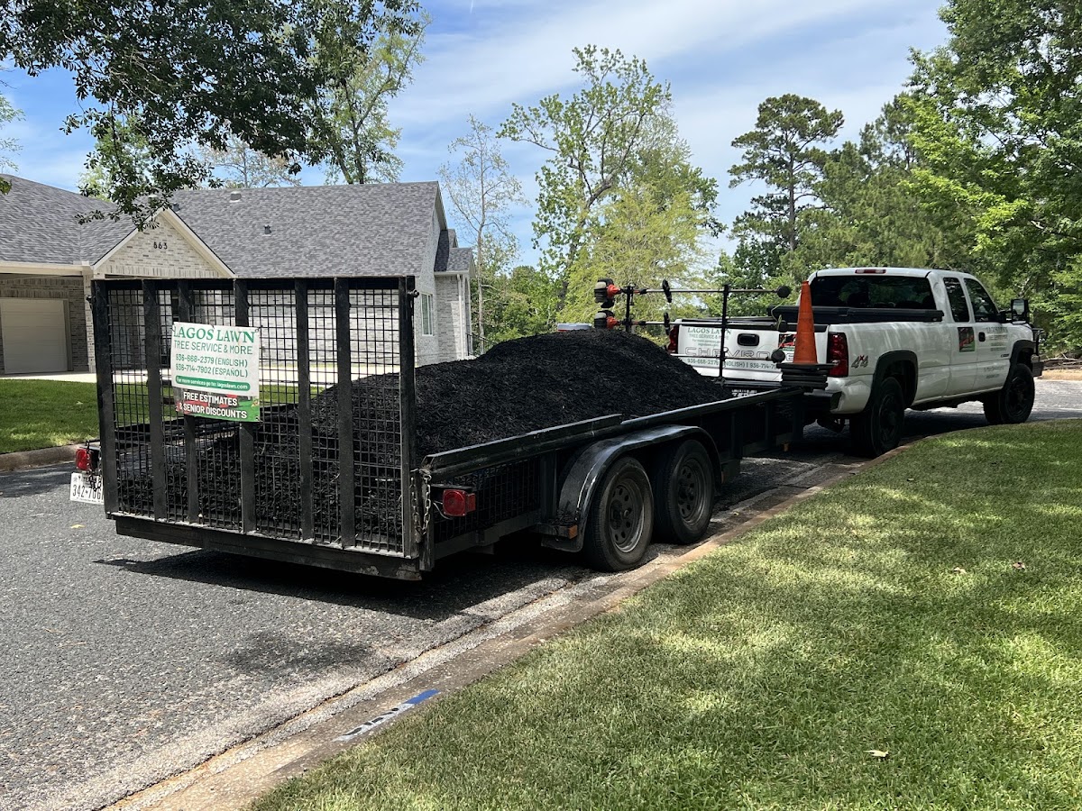 Lagos Lawn branded truck and trailer loaded with mulch on a Huntsville job